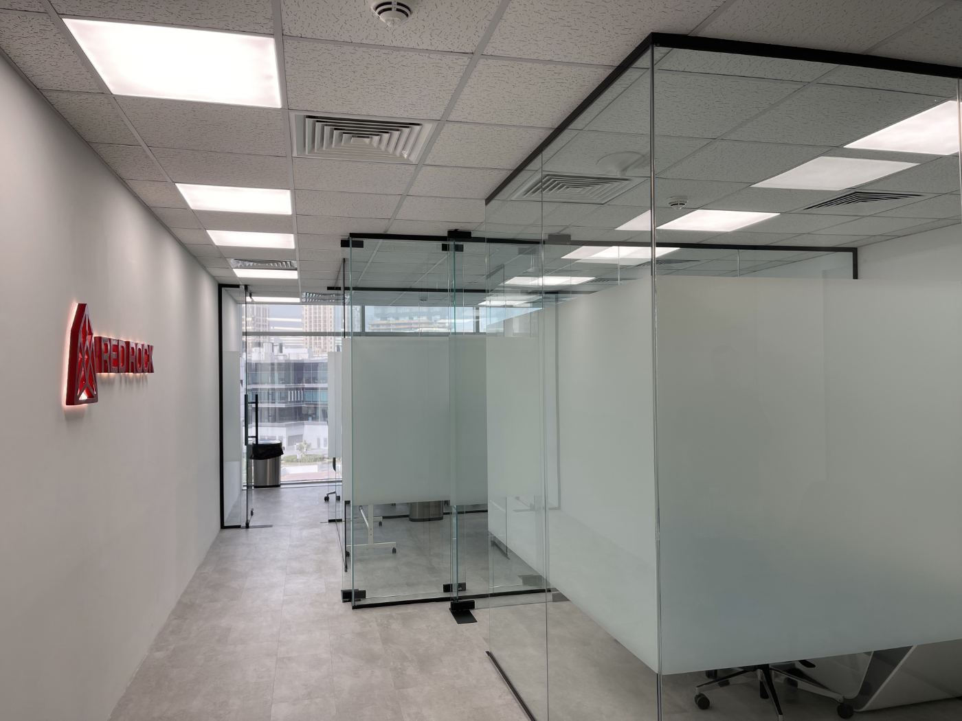 Office corridor with the backlit Red Rock sign and glass meeting rooms